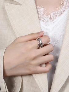 Detail shot of multi-layer silver winding ring on finger with soft business attire