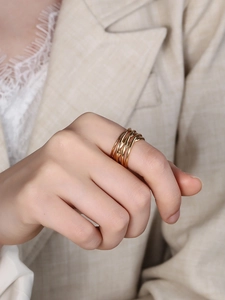Macro detail of multi-layer interwoven gold ring showing the textured woven design