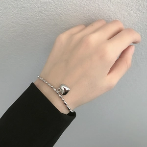 925 silver heart charm bracelet with polished olive beads worn on wrist, minimalist style