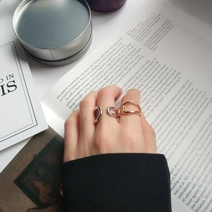 Detail of three mixed gold and silver minimalist organic irregular rings on a hand