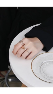Detailed shot of 925 silver layered ring set with gold chain and pearl on hand