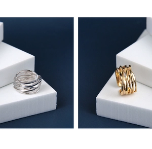 Detail of multi-layer intertwined silver and gold S925 rings on geometric stairs
