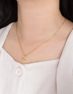 Gros plan d'un collier spirale minimaliste en argent 925 doré porté au cou