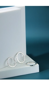 Detailed close-up of three minimalist polished 925 sterling silver rings on a stand