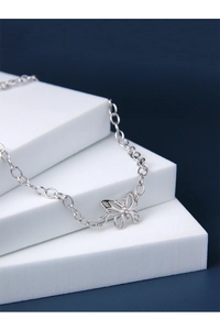 Gros plan d'un pendentif papillon en argent avec cristaux sur chaîne fine