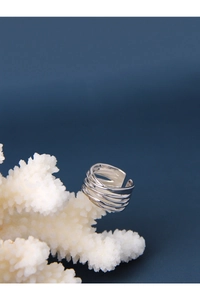 Macro shot of silver multi-layer layered geometric ring on white coral decor