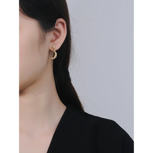 Elegant gold crescent moon earrings with unique hammered texture on a female model