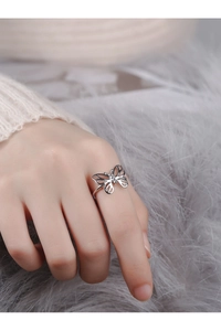 Macro detail of silver butterfly ring with intricate cutout wings on an open adjustable band