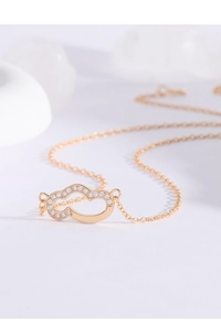 Macro detail of gold cloud pendant necklace with pavé-set zircons on cross chain