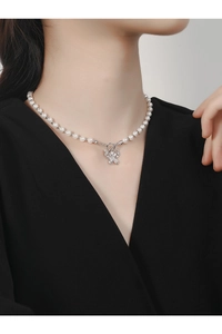 Detail of S925 silver butterfly pendant with cubic zirconia and T-bar pearl necklace