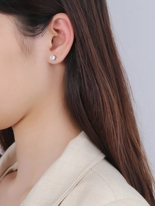Gros plan de boucles d'oreilles en argent avec zircons ronds sertis de six griffes