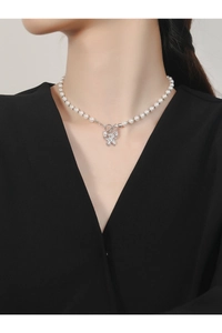 Close-up of S925 silver butterfly necklace with zircons and pearls on a female neck