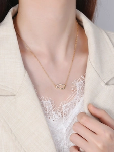 Detail of gold cloud necklace with pavé cubic zirconia on minimalist interlocking pendant