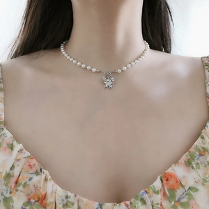 Detailed close-up of S925 silver butterfly necklace with pearls and zircon on model