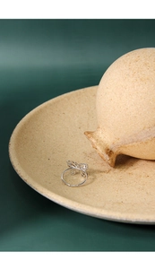 Close-up of S925 sterling silver butterfly ring with adjustable open band on ceramic plate