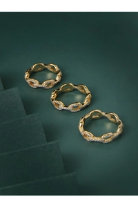 Gros plan de trois bagues gourmette plaquées or ornées de zircons cubiques brillants