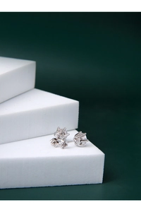 Détail de boucles d'oreilles en argent avec serti à six griffes et zircone sur escalier