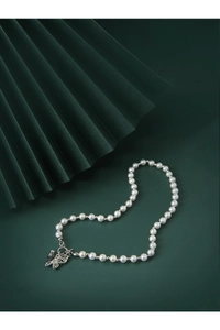 Detailed view of a silver butterfly clasp on a round white pearl necklace