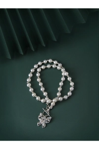 Detail of S925 silver butterfly necklace with white pearls and sparkling zircon inlays