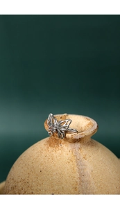 Detailed macro view of an S925 sterling silver butterfly ring on a clay pot edge