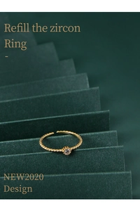 Detail of 925 silver adjustable gold ring with round zircon and beaded texture
