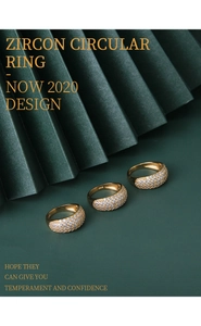 Close-up of three gold S925 silver rings with micro-pave zircon on emerald background