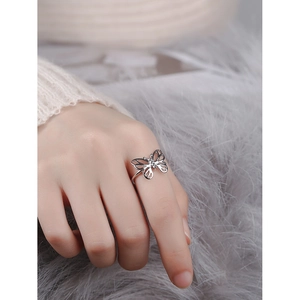 Elegant silver butterfly hollow ring with adjustable band shown on a woman finger