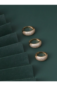 Macro detail of three gold plated S925 silver rings with pavé set zircon stones