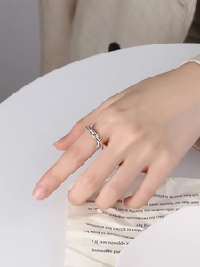 Primo piano di un anello a nodo minimalista in argento sterling S925 sulla mano della modella