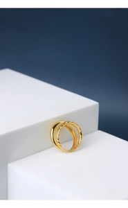 Detail view of double-layer gold open ring featuring twisted rope texture and polished band