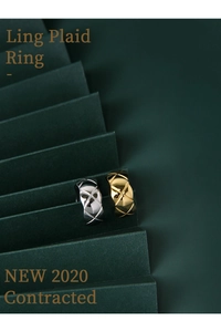 Close-up of gold and silver S925 sterling silver rings with quilted pattern on green background
