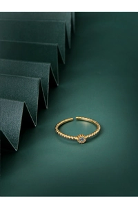 Macro detail of adjustable gold bead ring with a sparkling white round zircon gemstone