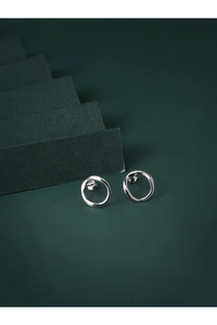 Macro detail of S925 sterling silver irregular hoop earrings on a green display stand