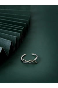 Vista dettagliata dell'anello nodo in argento su sfondo origami verde scuro con trama metallica