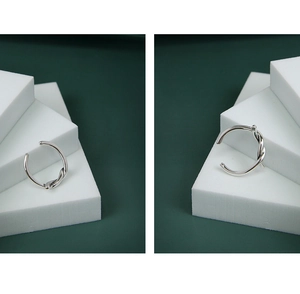 Dettaglio macro dell'anello a nodo in argento sterling S925 lucido su base geometrica