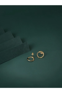 Detailed view of golden irregular round stud earrings with textured organic finish on velvet
