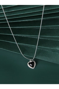 Detail of silver heart pendant with black onyx and beaded metal edge on ball chain