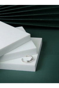 Dettaglio del punzone S925 su un anello a nodo in argento minimalista e trama metallica