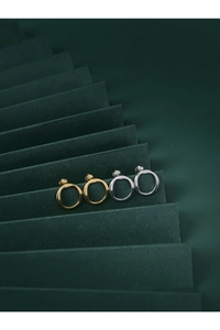 Detailed macro view of minimalist irregular round hoop earrings in gold and silver finish