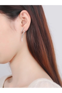 Détail de boucles d'oreilles vagues en argent S925 avec zircons portées par un mannequin