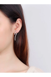 Détail macro d'une boucle d'oreille en argent S925 avec zircons scintillants sur modèle