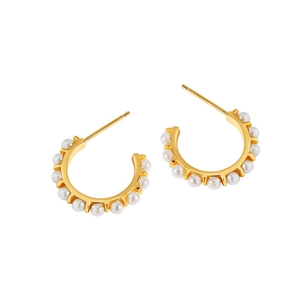 Elegant gold C-shaped hoop earrings with inlaid white pearls on white background