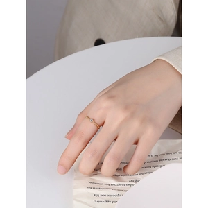 Minimalist 925 silver beaded gold ring with central cubic zirconia on model's hand