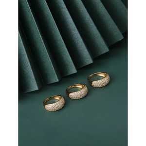 Three-piece S925 sterling silver gold ring set with cubic zirconia on green background