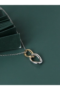 Detail of interlocking gold and silver teardrop pendants on a minimalist chain necklace