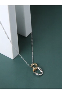 Detail of interlocking gold and silver irregular oval rings on a slender chain