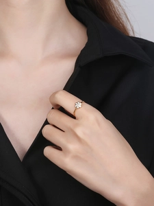 Close-up of golden daisy flower ring on finger with white enamel petals for women