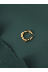 Détail du poinçon S925 sur une bague d'oreille en argent doré de forme minimaliste