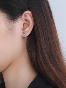 Macro detail of S925 sterling silver heart crown stud earring worn on model's ear