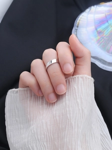 Close-up of a minimalist S925 sterling silver wide band ring worn on a female finger